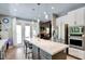 Modern kitchen with stainless appliances, an island with pendant lighting, and access to the backyard at 1701 Tesara Vista Pl, Las Vegas, NV 89128