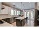 Well-lit kitchen with stainless steel appliances, dual basin sink, and light wood grain floors at 1701 Tesara Vista Pl, Las Vegas, NV 89128