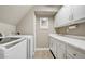 Well-lit laundry room equipped with a washer, dryer, sink, and ample cabinet space at 1701 Tesara Vista Pl, Las Vegas, NV 89128