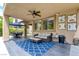 Covered patio with ceiling fan, seating, and access to the landscaped backyard and outdoor dining area at 1701 Tesara Vista Pl, Las Vegas, NV 89128