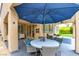 Covered patio with a dining table, lounge area, ceiling fan, and access to the landscaped backyard at 1701 Tesara Vista Pl, Las Vegas, NV 89128