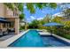 Backyard featuring a modern pool, covered patio area, lush landscaping and inviting lounge spaces at 1701 Tesara Vista Pl, Las Vegas, NV 89128