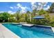 Backyard featuring a modern pool, with lush landscaping and inviting lounge spaces at 1701 Tesara Vista Pl, Las Vegas, NV 89128