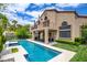 Exterior view of a stucco home with a refreshing pool and a covered patio for outdoor enjoyment at 1701 Tesara Vista Pl, Las Vegas, NV 89128