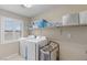 Bright laundry room with a washer, dryer, storage shelves, and window at 176 Jay Porter Ave, Henderson, NV 89002