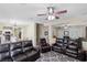 Open-concept living room boasts dark leather sofas, a ceiling fan, and a view into the dining and kitchen areas at 176 Jay Porter Ave, Henderson, NV 89002