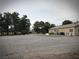 Spacious gravel backyard with various outbuildings and structures, complemented by lush trees at 1930 N Murphy St, Pahrump, NV 89060