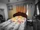 Comfortable bedroom featuring a cozy unicorn themed bed and a window with curtains at 1930 N Murphy St, Pahrump, NV 89060