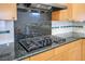 Kitchen featuring a gas cooktop with black granite countertops and backsplash at 1978 Kachina Mountain Dr, Henderson, NV 89012