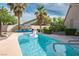 Backyard swimming pool surrounded by lush tropical palm trees under a blue sky at 1978 Kachina Mountain Dr, Henderson, NV 89012