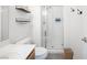 Bright bathroom featuring a walk-in shower, modern fixtures, and floating shelves for stylish storage solutions at 2208 Dale Bumpers Ct, North Las Vegas, NV 89081
