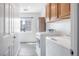 Well-lit laundry room featuring modern washer and dryer units, storage cabinets, and a window with neighborhood views at 2208 Dale Bumpers Ct, North Las Vegas, NV 89081