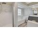 Bathroom features a tub, glass shower, and modern white marbled tile at 2224 Lucerne Ct, Henderson, NV 89014