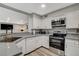 Modern kitchen with stainless steel appliances, light countertops, and a view into the open-plan living space at 2224 Lucerne Ct, Henderson, NV 89014