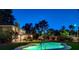 The Kidney-shaped pool is illuminated, creating a stunning view from the patio and backyard at 2224 Lucerne Ct, Henderson, NV 89014
