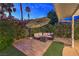 Outdoor patio area with a sun umbrella, comfortable seating, and landscaped yard at 2231 Marlboro Dr, Henderson, NV 89014