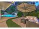 Outdoor patio area with a pool, comfortable seating, and manicured landscaping at 2231 Marlboro Dr, Henderson, NV 89014