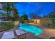 Inviting backyard featuring a pool, lounge chairs, and a covered patio with dining area, perfect for entertaining at 2231 Marlboro Dr, Henderson, NV 89014