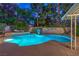 Inviting backyard pool featuring a basketball hoop, lounge chairs and lush tropical landscaping illuminated at twilight at 2231 Marlboro Dr, Henderson, NV 89014