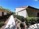 View of the side of the home, showing the walkway and desert landscaping on a bright, sunny day at 2480 Domingo St, Las Vegas, NV 89121