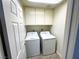 Laundry room featuring tile flooring, laundry machines and overhead storage at 2480 Domingo St, Las Vegas, NV 89121