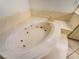 Relaxing bathroom featuring a large whirlpool tub, a golden faucet, and marble countertops at 2540 Faiss Dr, Las Vegas, NV 89134