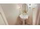 Elegant powder room with pedestal sink, decorative mirror, and stylish lighting at 2540 Faiss Dr, Las Vegas, NV 89134