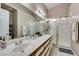 Bathroom featuring a double sink vanity, shower with glass doors, and large mirror at 2595 Fort Lauderdale Dr, Las Vegas, NV 89156