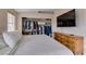 Bedroom with a bed, wooden dresser, built-in closet with clothes, and a TV mounted on the wall at 2595 Fort Lauderdale Dr, Las Vegas, NV 89156