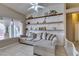 Comfortable living room with tiled floors, a ceiling fan, bright windows and floating shelves at 2595 Fort Lauderdale Dr, Las Vegas, NV 89156