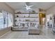 Cozy living room with tiled floors, a ceiling fan, bright windows and floating shelves at 2595 Fort Lauderdale Dr, Las Vegas, NV 89156