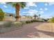 Backyard landscape design with a gravel pathway, shrubbery and palm trees at 2605 Lotus Hill Dr, Las Vegas, NV 89134
