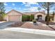 Beautifully landscaped single-story home showcasing a charming entrance and a well-kept front yard with mature trees at 2605 Lotus Hill Dr, Las Vegas, NV 89134