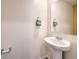 Well-lit powder room features a pedestal sink, chrome faucet, decorative mirror and towel bar for added convenience at 2617 Snapdragon Falls Ave # 100, North Las Vegas, NV 89081
