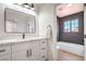 Bathroom with a modern vanity, large mirror, and a glimpse of a well-lit tiled shower and bathtub at 2713 Beachside Ct, Las Vegas, NV 89117