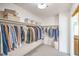 Walk-in closet with a variety of hanging garments, shelves and neutral colored carpet at 2713 Beachside Ct, Las Vegas, NV 89117