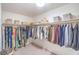 Walk-in closet featuring ample shelving, a closet rod holding a variety of hanging garments, and neutral-colored carpeting at 2713 Beachside Ct, Las Vegas, NV 89117