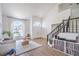 Bright living room with high ceilings, arched windows, modern decor, and black metal staircase at 2713 Beachside Ct, Las Vegas, NV 89117