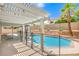 Backyard pool area under a pergola with a safety fence and a tall palm tree at 2713 Beachside Ct, Las Vegas, NV 89117