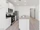 Bright kitchen boasts white cabinetry, stainless steel appliances, an island with sink, and modern fixtures at 2727 Avril Point St, Las Vegas, NV 89156