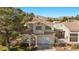 Two-story home with desert landscaping, well-maintained lawn, and a two-car garage at 3425 Creek River Dr, Las Vegas, NV 89129