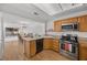 Open-concept kitchen and dining area, with breakfast bar, stainless steel appliances and wooden table at 3425 Creek River Dr, Las Vegas, NV 89129