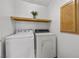 Efficient laundry room features a washer, dryer, and overhead shelving for convenient storage solutions at 3425 Creek River Dr, Las Vegas, NV 89129