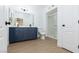 Bathroom with navy vanity, double sinks, modern fixtures, and a glass-enclosed shower at 3608 Pintadas St # 204, Las Vegas, NV 89108