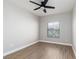 Comfortable bedroom showcasing a ceiling fan, wood-look flooring, and a window with neighborhood views at 3608 Pintadas St # 204, Las Vegas, NV 89108