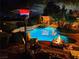 Enjoy evenings relaxing by the sparkling in-ground pool and firepit in this peaceful backyard retreat at night at 3619 Bixbee Ct, Las Vegas, NV 89129