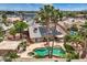 Aerial view of backyard featuring a uniquely shaped pool, jacuzzi, patio, and desert landscaping at 3619 Bixbee Ct, Las Vegas, NV 89129