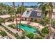 Lush backyard featuring a uniquely shaped pool, spa, mature palm trees, and desert landscaping at 3619 Bixbee Ct, Las Vegas, NV 89129