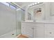 This bathroom includes a glass shower, white vanity with plenty of storage and bright lighting for a clean aesthetic at 3808 Lilac Haze St, Las Vegas, NV 89147