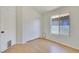 Bright bedroom with wood-look flooring, closet, and window offering natural light and pet door at 3808 Lilac Haze St, Las Vegas, NV 89147